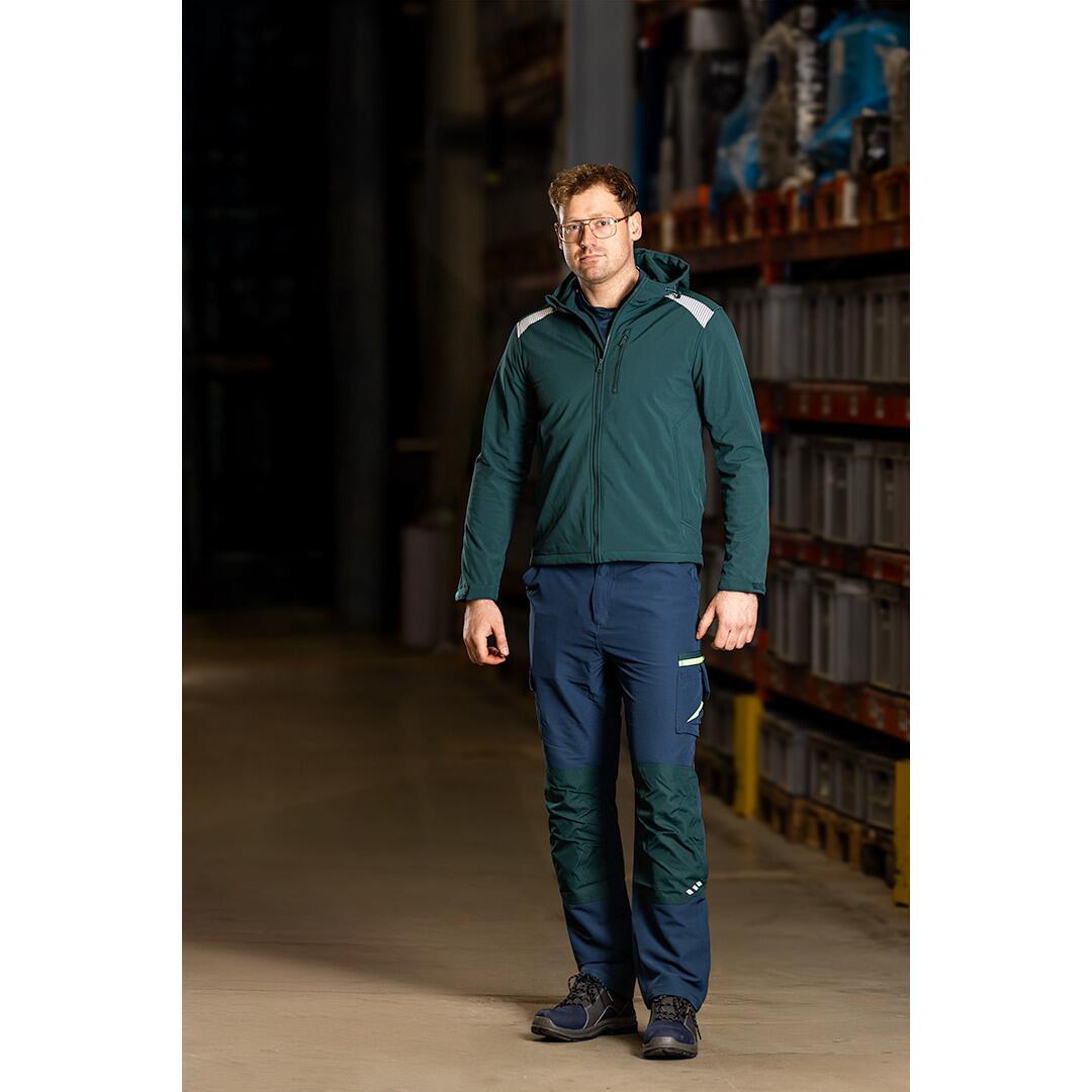 Muncitor purtand pantalonii de lucru elastici NEO Mix&Match bleumarin si verde